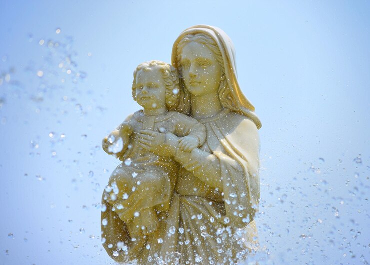 Foto close-up de estátua de maria e jesus contra fundo azul