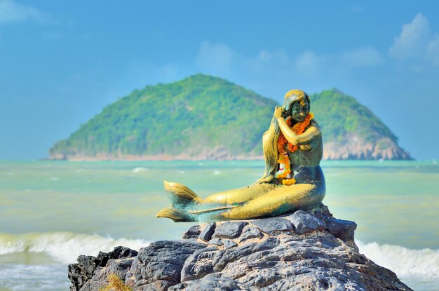 Close-up de estátua em pedra contra a praia