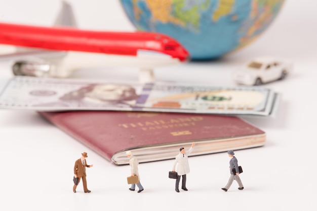 Foto close-up de estatuetas com passaporte e moeda sobre a mesa