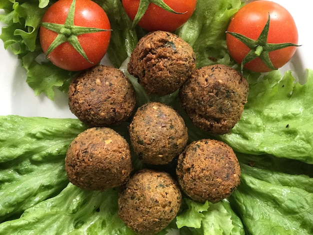 Foto close-up de falafels com tomates cereja e alface em prato