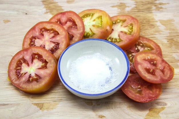 Close-up de fatias de tomate com sal em uma tigela na mesa