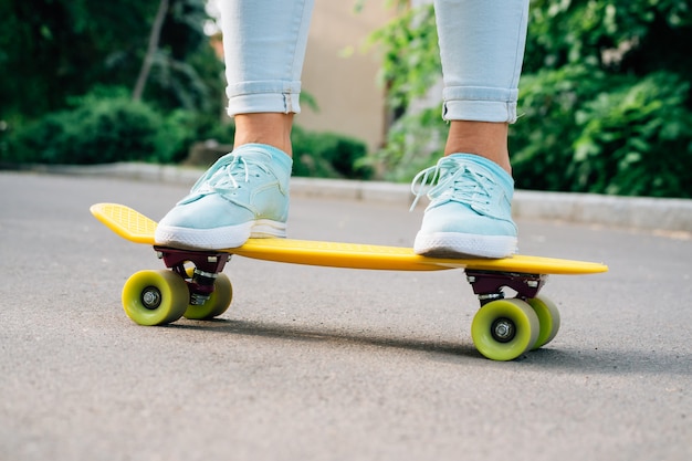 Close-up, de, femininas, pernas, em, calças jeans, e, tênis, ficar, ligado, um, amarela, skateboard