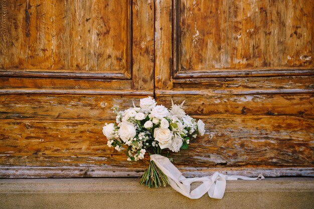 Foto close-up de flores brancas em uma porta de madeira