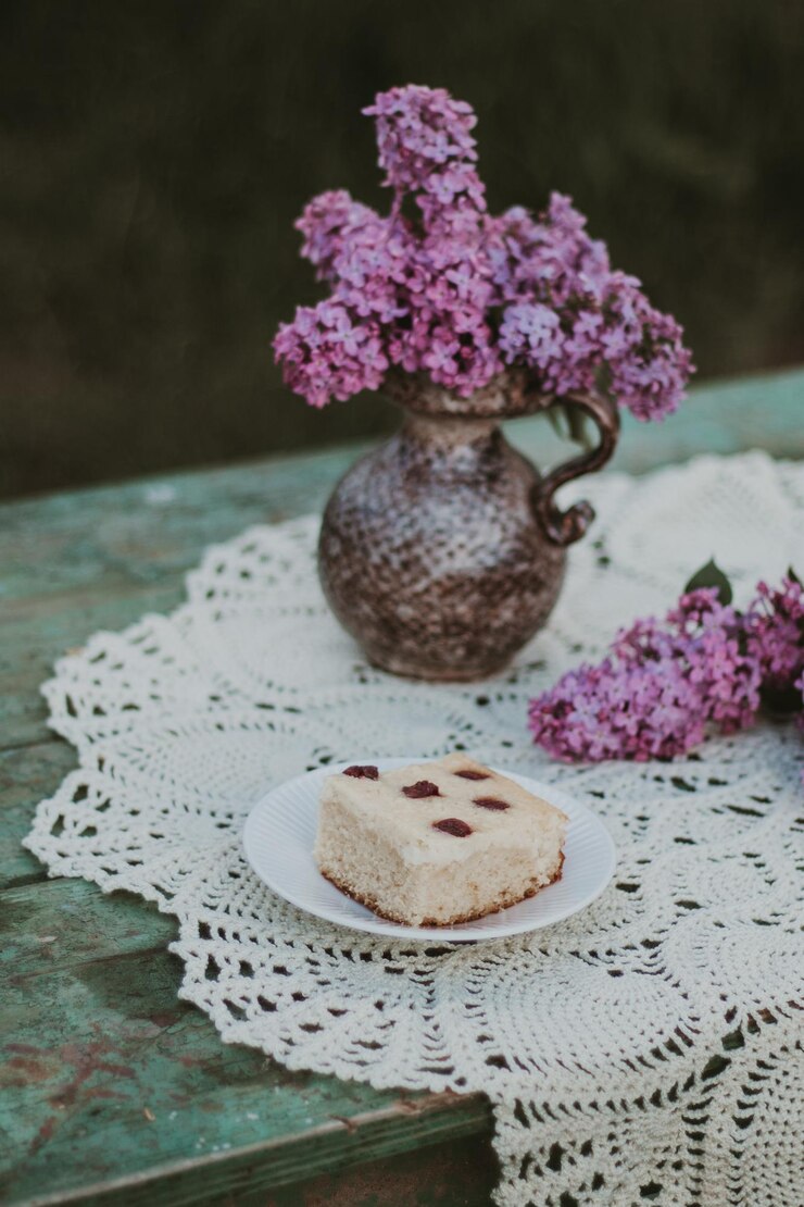 Foto close-up de flores púrpuras frescas na mesa e uma fatia de torta de queijo
