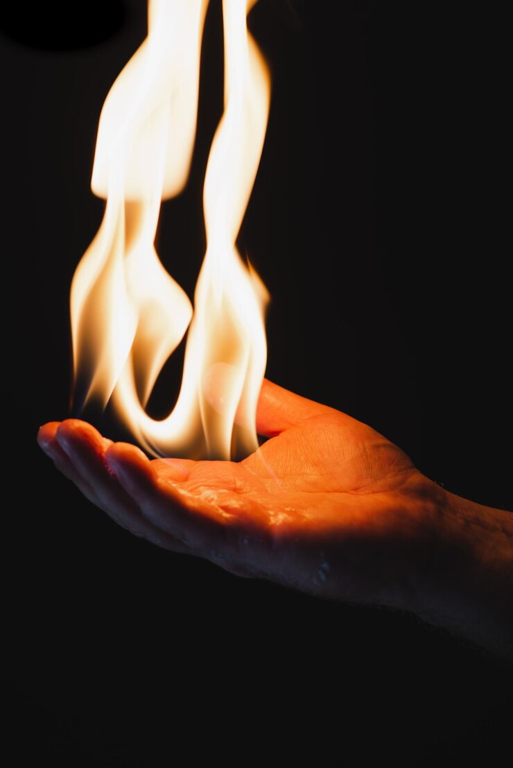 Foto close-up de fogo na mão contra fundo preto