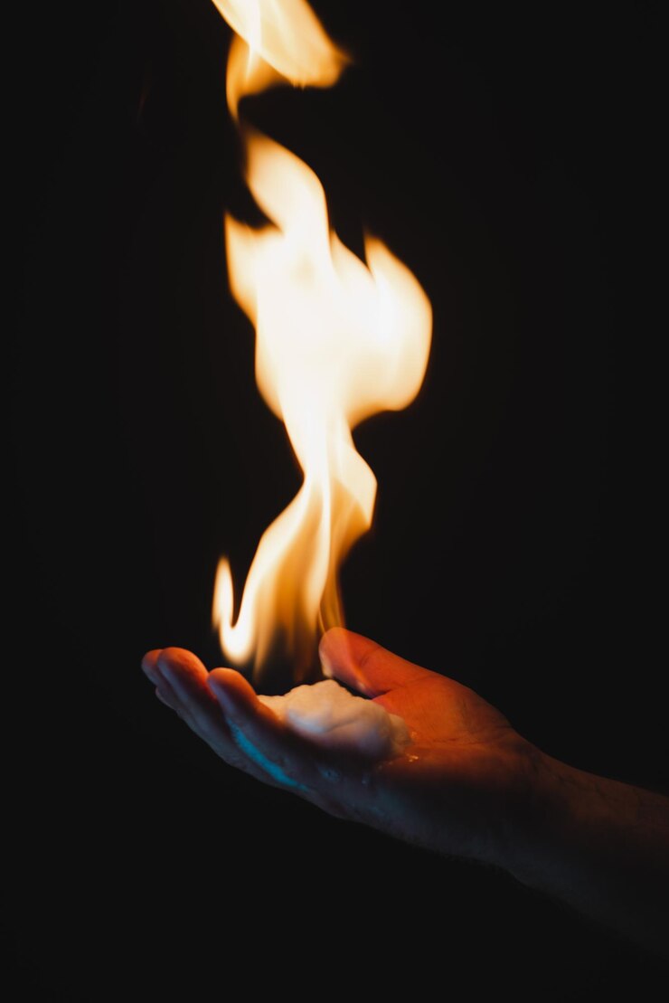 Foto close-up de fogo na mão contra fundo preto