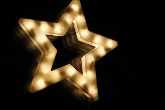 Close-up de forma de estrela iluminada contra o céu à noite