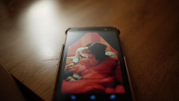 Foto close-up de fotografia de menina em telefone celular na mesa