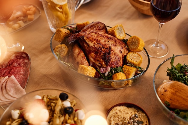 Close-up de frango assado na mesa de jantar com pratos caseiros rústicos em ambiente aconchegante