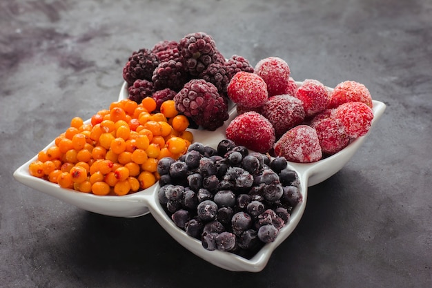 Close up de frutas e bagas congeladas em uma mesa preta alimentos saudáveis vitaminas lanche sobremesa