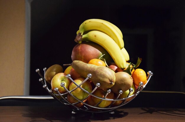 Foto close-up de frutas em cesta metálica na mesa