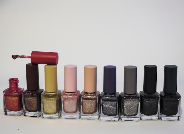 Close-up de garrafas de esmalte de unhas contra fundo branco