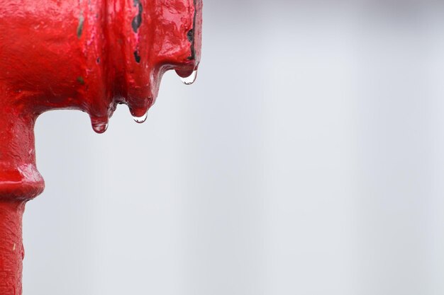 Foto close-up de gotas de água em hidrante de incêndio contra céu claro