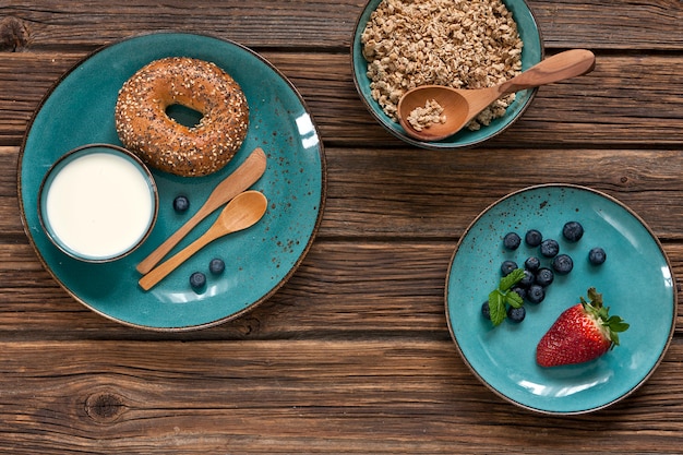 Close-up de granola com frutas frescas, leite e donuts.