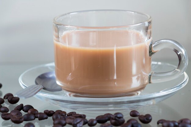 Foto close-up de grãos de café e xícara na mesa