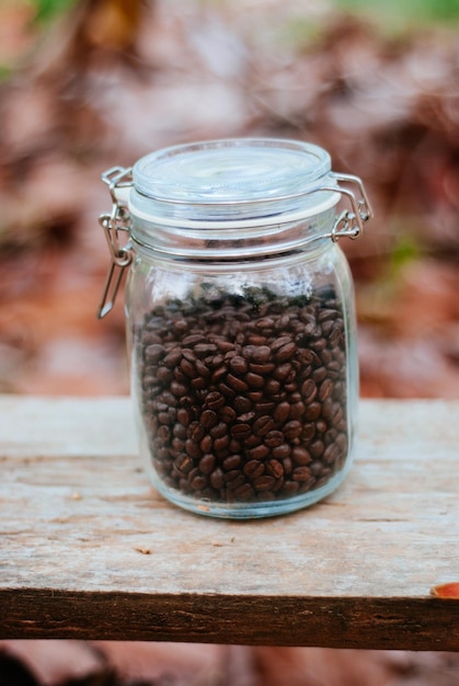 Foto close-up de grãos de café em frasco de vidro na mesa