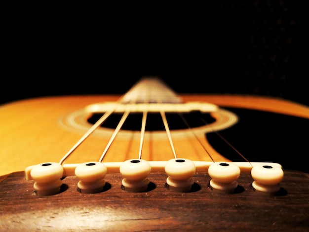 Foto close-up de guitarra contra fundo preto
