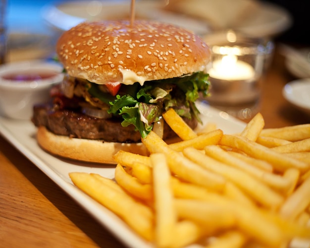 Close-up de hambúrguer com batatas fritas em prato na mesa