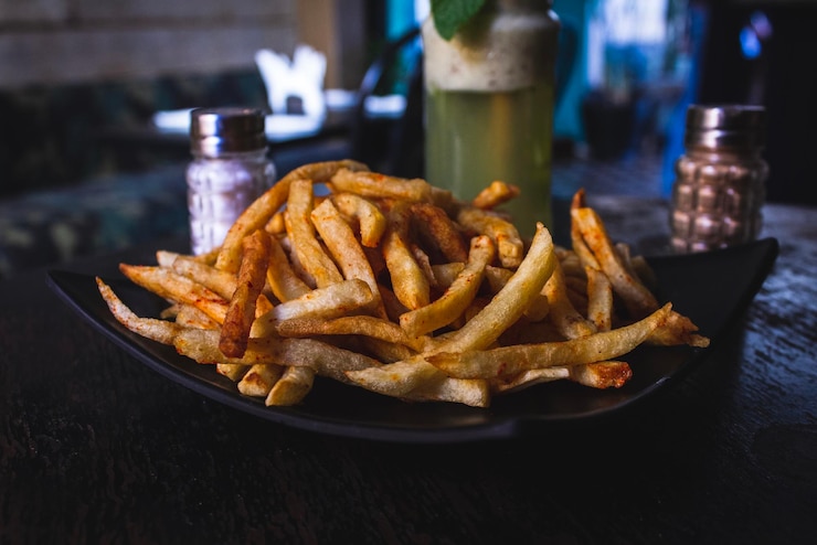 Foto close-up de hambúrguer com carne e batatas fritas em prato na mesa