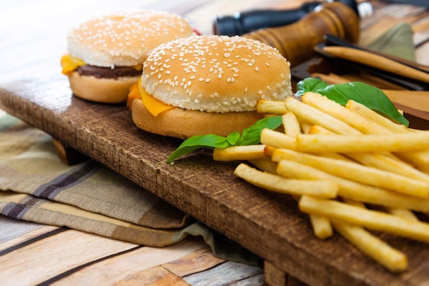 Close-up de hambúrguer e batatas fritas na tábua de cortar