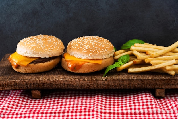 Close-up de hambúrguer e batatas fritas na tábua de cortar