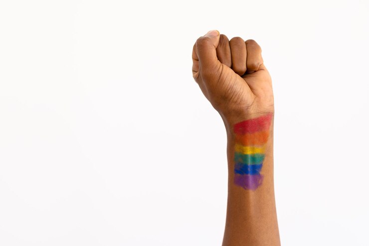 Foto close-up de homem afro-americano com bandeira arco-íris pintura de mão apertando o punho sobre parede branca. espaço de cópia, inalterado, direitos lgbtqia, homossexual, cortado e símbolo do orgulho gay conceito.