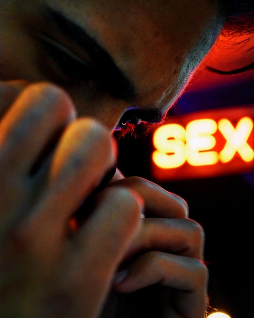 Foto close-up de homem contra texto sexual iluminado