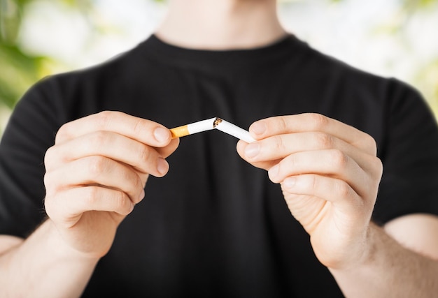 close-up de homem quebrando o cigarro com as mãos