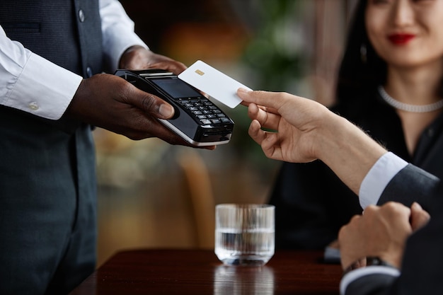 Close-up de hóspede pagando com cartão de crédito em um restaurante de luxo