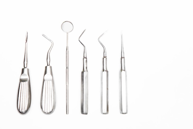 Close-up de instrumentos dentários sobre fundo branco