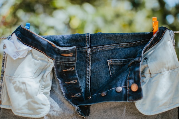 Foto close-up de jeans pendurados na corda de roupa