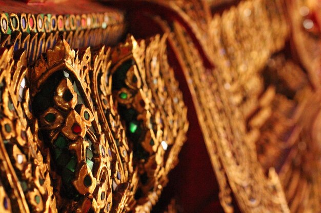 Foto close-up de jóias de ouro na estátua de buda em wat pho