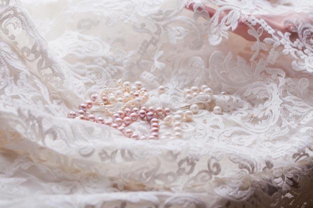 Foto close-up de jóias de pérolas em tecido de renda