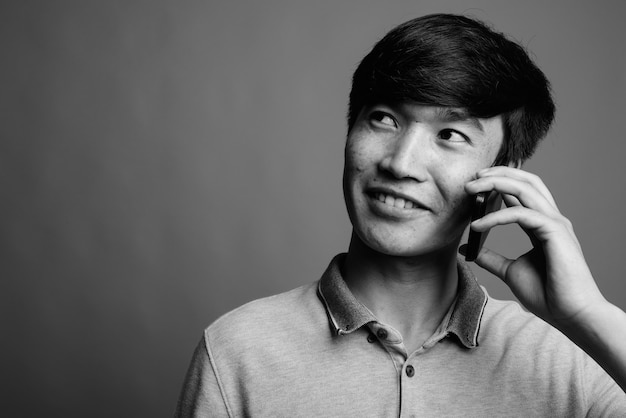 Close-up de jovem asiático usando telefone celular