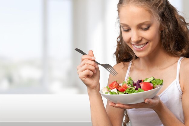 Close-up de jovem feliz comendo salada