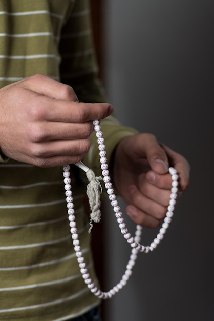 Close-up de jovem muçulmano com o Rosário rezando na mesquita