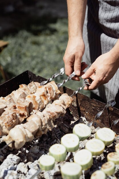 Close-up de kebabs em espetos homem grelhando carne ao ar livre