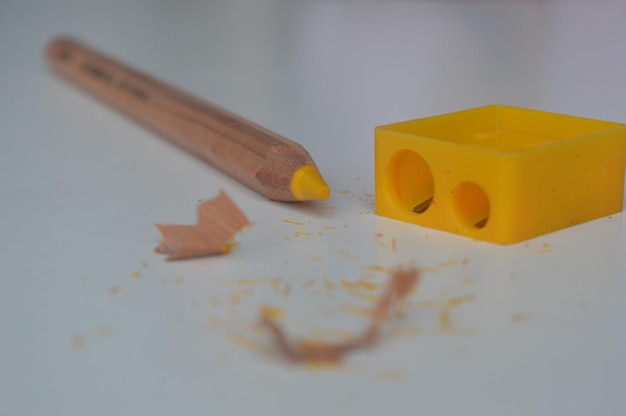 Close-up de lápis amarelo e afiador em mesa branca