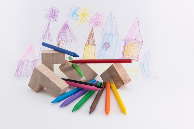 Foto close-up de lápis coloridos com blocos de brinquedo em fundo branco