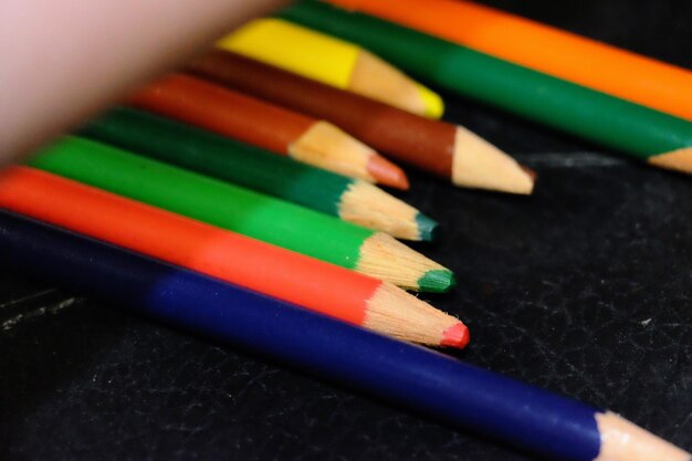 Foto close-up de lápis coloridos em mesa preta