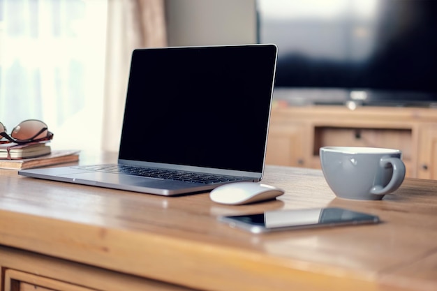 Close-up de laptop com telefone móvel e xícara de café na mesa