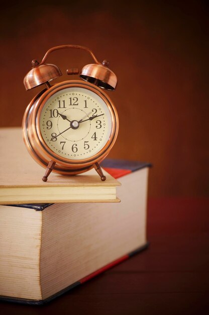 Foto close-up de livros e relógio na mesa