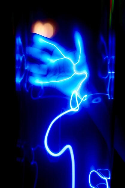 Close-up de luz azul iluminada contra a mão humana