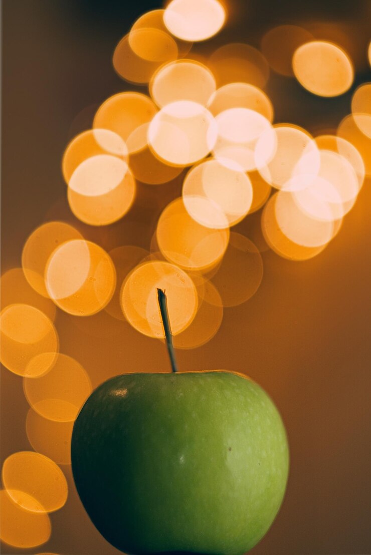 Foto close-up de maçã verde na mesa contra as luzes das fadas