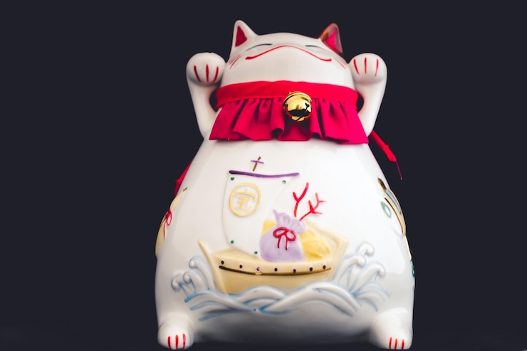 Foto close-up de maneki neko contra fundo preto