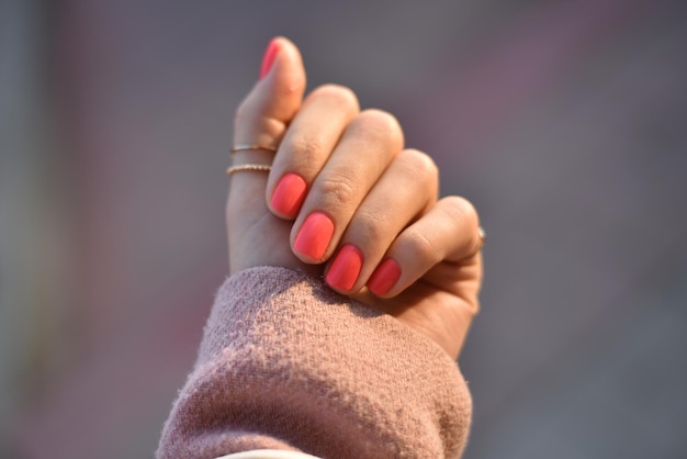 Close-up de mão de mulher com unhas cor-de-rosa
