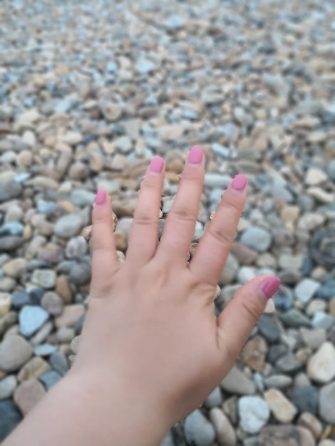 Foto close-up de mão de mulher sobre pedras de seixos