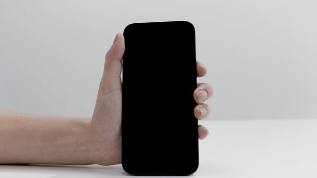 Close-up de mão feminina ativando novo smartphone bonito isolado em ação de fundo branco