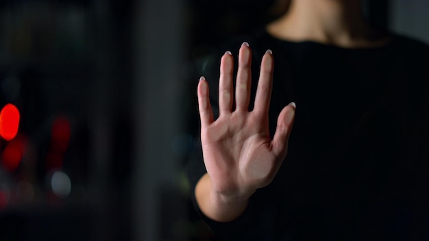 Foto close-up de mão feminina tocando parede de vidro dentro de casa menina deixando impressão da mão