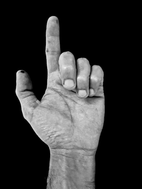 Foto close-up de mão humana apontando contra fundo preto